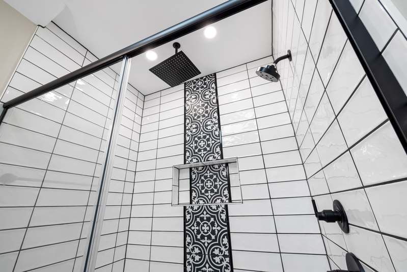 Modern bathroom with built-in tiled shower niche holding soap and shampoo bottles